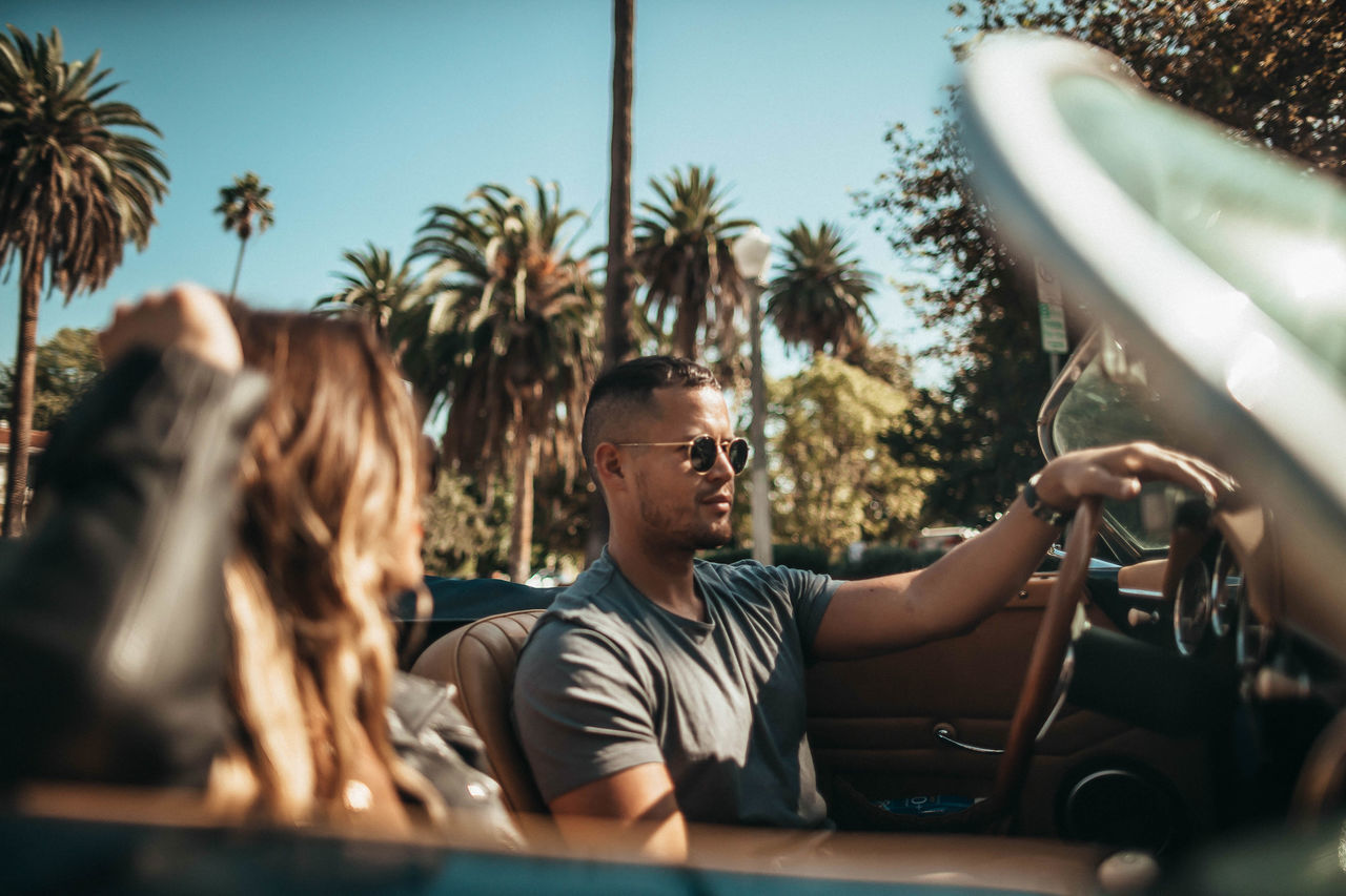 PORTRAIT OF PEOPLE SITTING ON PALM TREES