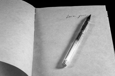 High angle view of pen on open book against black background