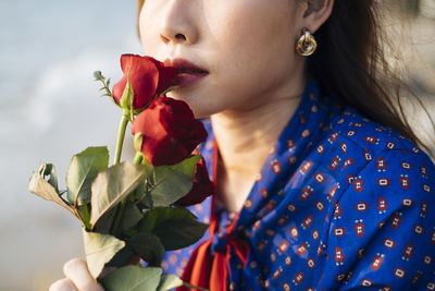 Close-up of young woman holding rose