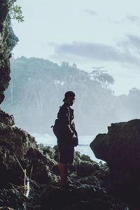 Side view of man standing on rock