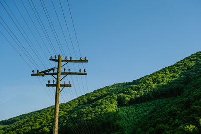 Low angle view of electricity pylon against sky