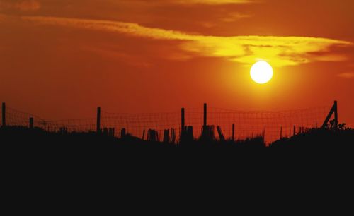 Scenic view of silhouette landscape against orange sky