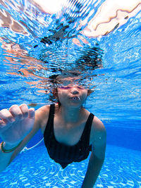 Portrait of young woman swimming in pool