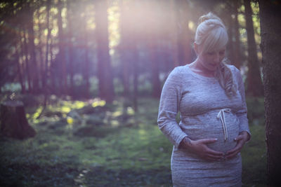 Midsection of woman standing in forest