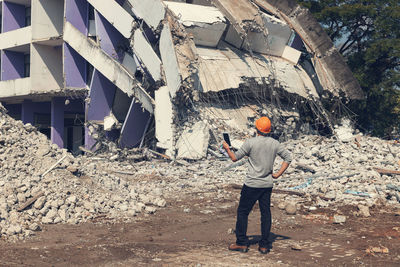 Rear view of man standing by building