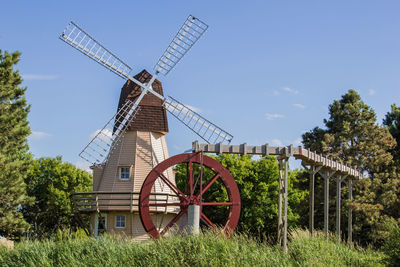 Traditional windmill on field against sky