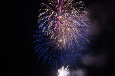 Low angle view of fireworks display at night