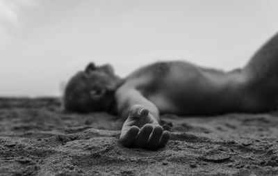 Monochrome of shirtless adult man lying on beach