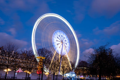 Low angle view of illuminated ferris wheel against sky at night