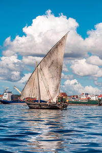 Sailboat sailing on sea against sky