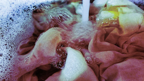 Close-up of human hand against sea