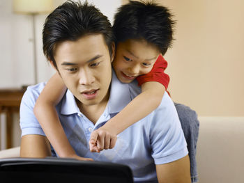 Father with son using laptop at home
