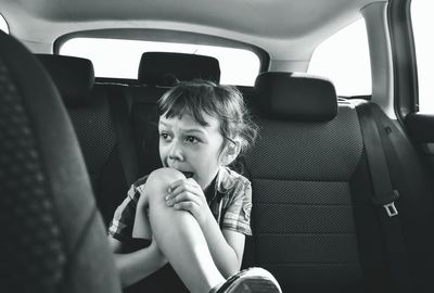 Close-up of crying boy sitting in car