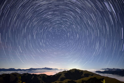 Scenic view of mountains against sky at night