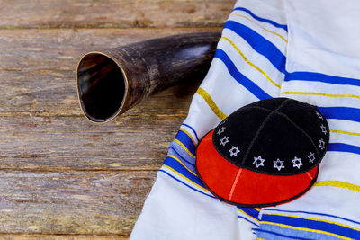 High angle view of shofar with cap and fabric on table