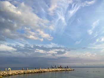 Group of people on jetty along the sea