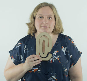Portrait of young woman standing against white background