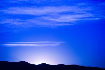 Scenic view of mountains against blue sky