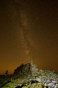 Low angle view of rock formation against sky at night