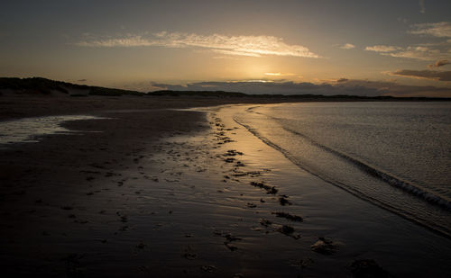 Scenic view of beach against sky during sunset