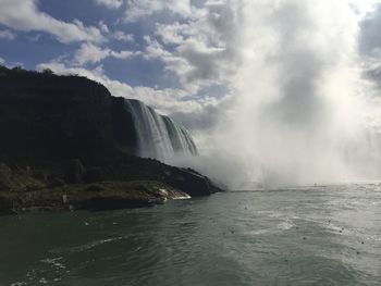 Scenic view of waterfall against sky