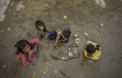 High angle view of girl sitting on sand