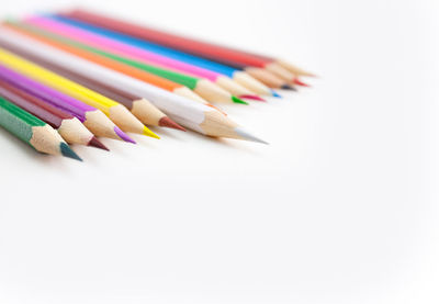 High angle view of colored pencils on white background