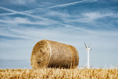 Hay bales on field against sky