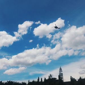 Low angle view of airplane flying against blue sky