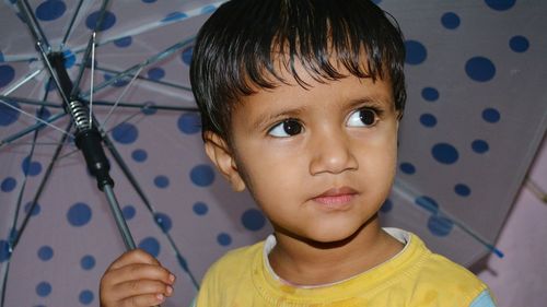 Close-up of kid holding umbrella