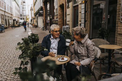 Senior couple drinking coffee in sidewalk cafe