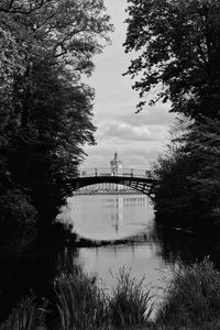 Bridge over lake and buildings against sky