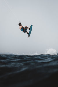 Man surfing in sea against sky