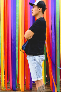 Full length of man standing against multi colored wall