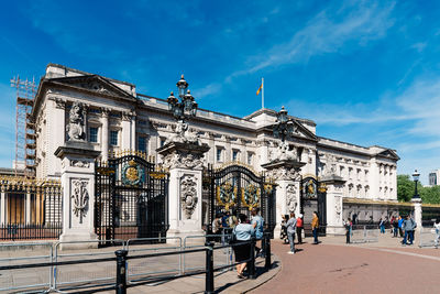 People in front of historical building against sky