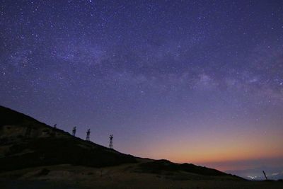 Low angle view of silhouette mountain against star field