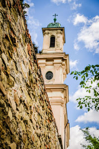 Low angle view of clock tower amidst buildings against sky