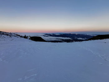 Scenic view of snow covered landscape against sky during sunset