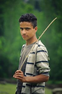 Young man standing against tree