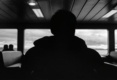 Rear view of man sitting in ferry boat