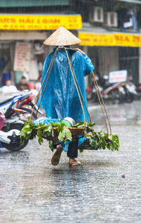 Rear view of person walking on wet street during monsoon