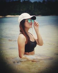 Young woman wearing sunglasses in lake