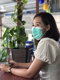 Portrait of woman holding potted plant