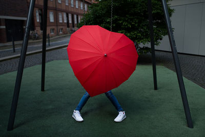 Low section of person with red umbrella