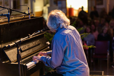Side view of man playing piano