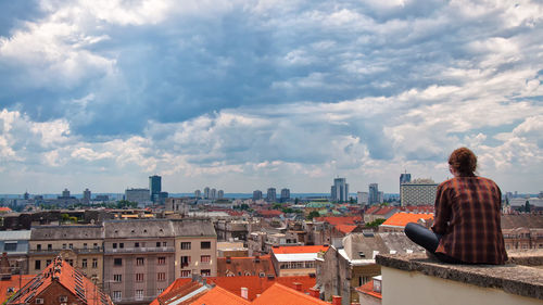 Buildings in city against cloudy sky