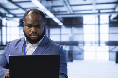 Portrait of young man using digital tablet at office