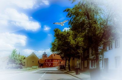 Houses amidst trees and buildings against sky