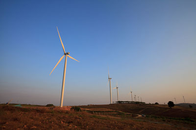 Windmill on field against clear sky