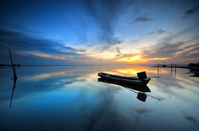 Silhouette boat in sea against sky during sunset